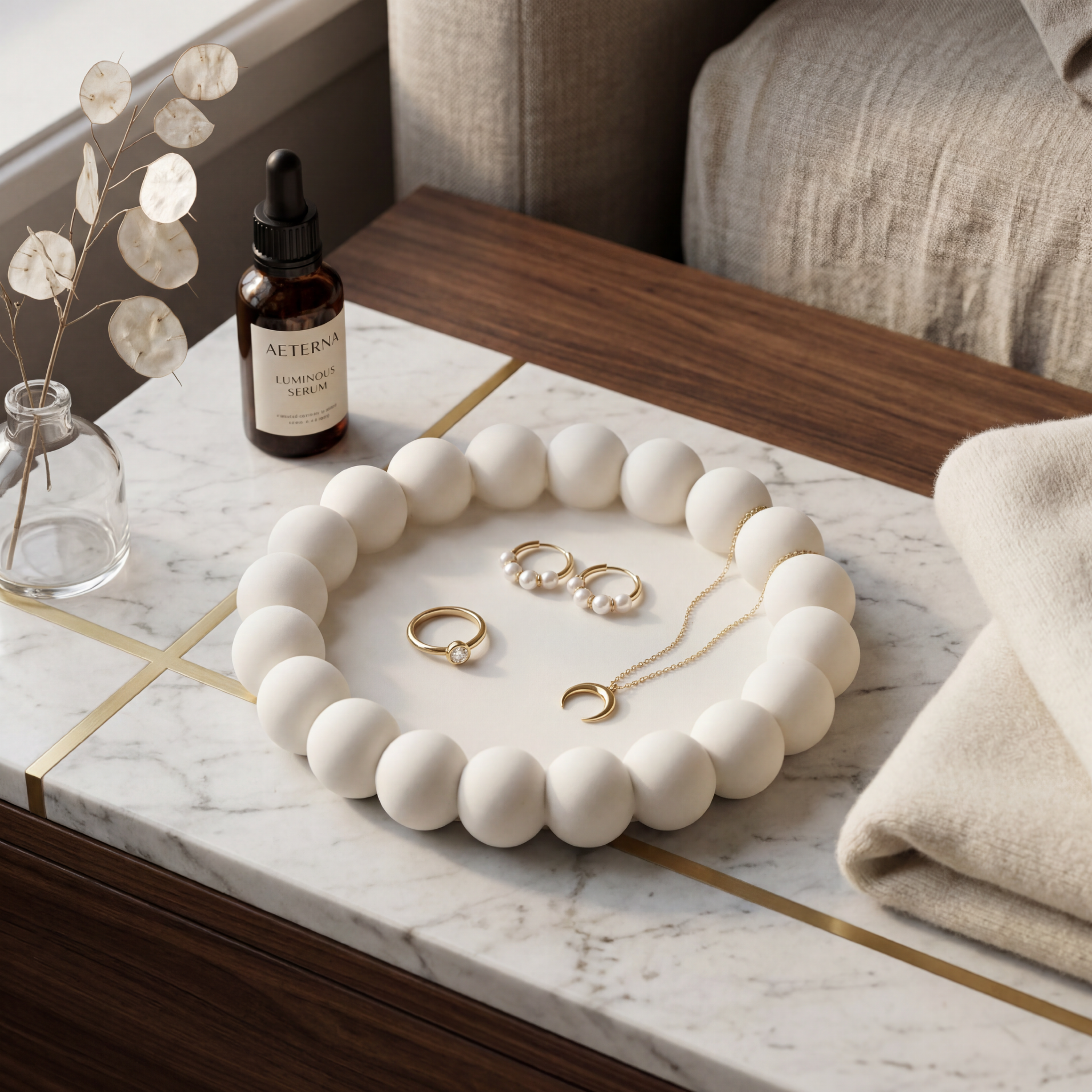 Jewelry set including a necklace and earrings on a marble surface with a bottle of serum.