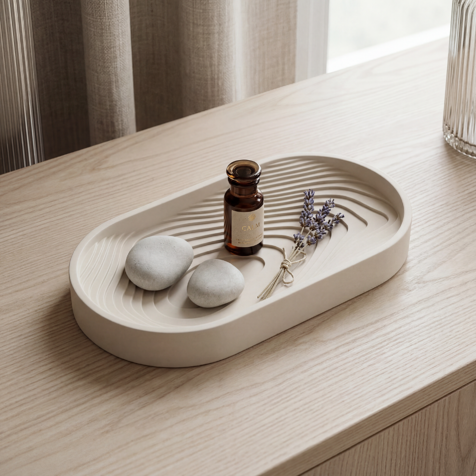 Decorative tray with stones, a bottle, and lavender on a wooden surface.
