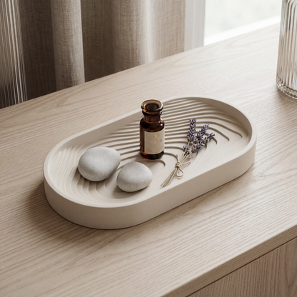 Decorative tray with stones, a bottle, and lavender on a wooden surface.